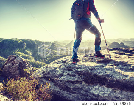 Hiker hold medicine stick,  injured knee fixed in 55989856