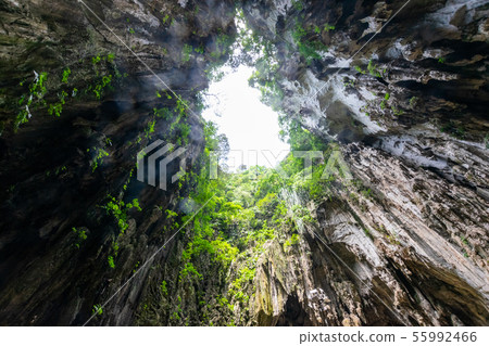 Mysterious light pouring into a cave Mysterious light pouring into a cave 55992466
