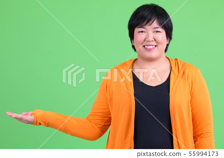 Young happy overweight Asian woman showing something ready for gym 55994173
