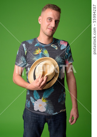 Portrait of handsome tourist man holding hat Portrait of handsome tourist man holding hat 55994287