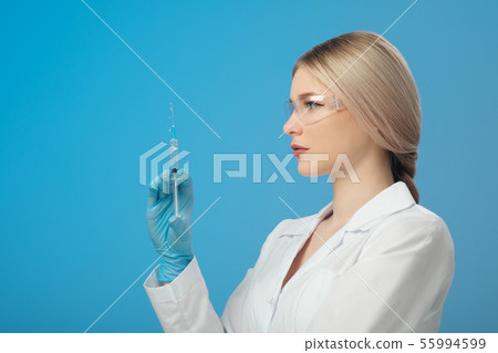 Woman's hand holding syringe and medicine vial prepare for injection in operating room. Space for Woman's hand holding syringe and medicine vial prepare for injection in operating room. Space for 55994599
