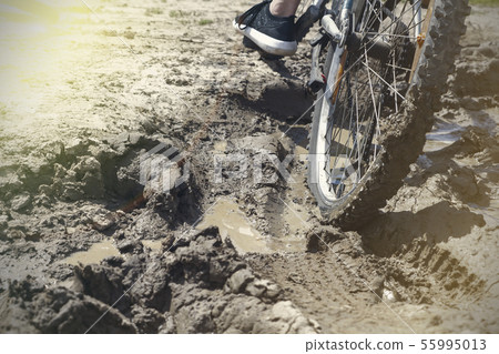 the Bicycle wheel is stuck in the mud. Close up 55995013