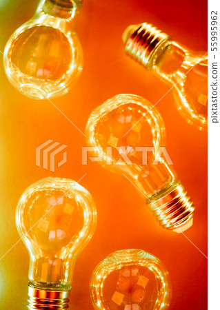 Creative pattern made of light bulbs in orange and red neon duotone. 55995962