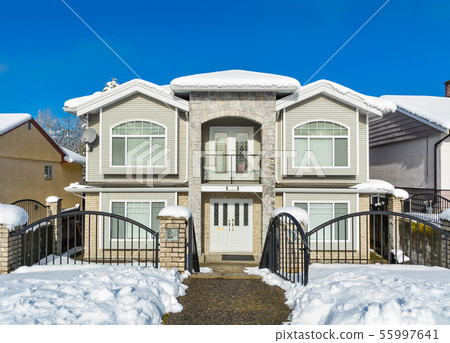 Luxury house with metal fence and opened entrance gage on blue sky background. 55997641
