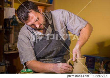 Professional male potter working in workshop, studio 55997714