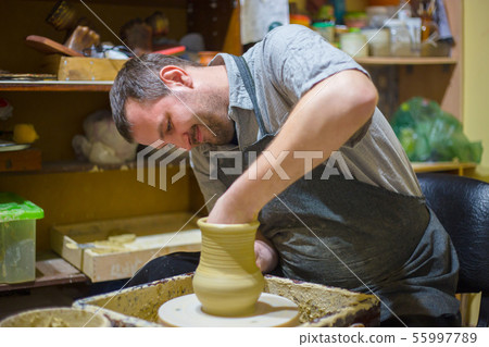 Professional male potter making jug in pottery workshop Professional male potter making jug in pottery workshop 55997789