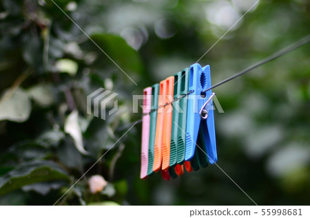 Clothespins on a rope hanging outside house and Clothespins on a rope hanging outside house and 55998681