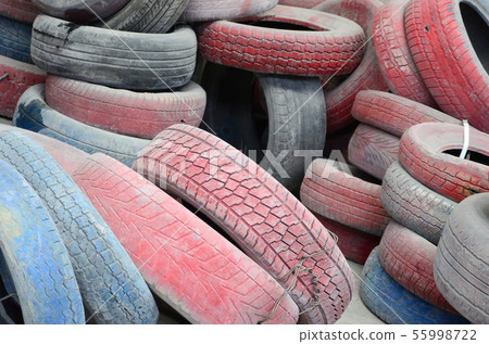 A picture of many old used tires left on a waste A picture of many old used tires left on a waste 55998722