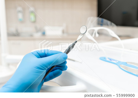 The hand of the dentist in the glove holds tool mirror. Stomatological instrument in the dentist 55999900