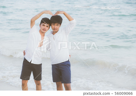 Homosexual asian couple on beach gesture heart Homosexual asian couple on beach gesture heart 56009066