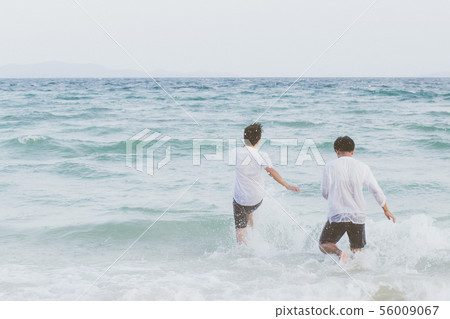Homosexual young asian couple running on beach Homosexual young asian couple running on beach 56009067