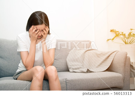 Severe migraine headache holding hands to head. 56013313