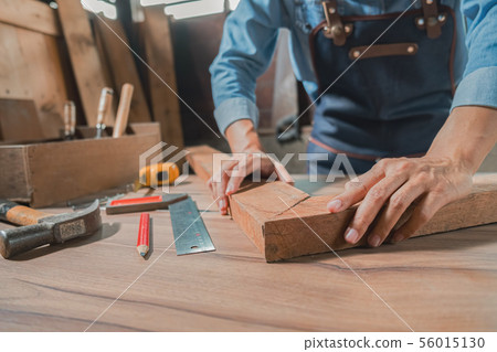 Carpenter working with equipment on wooden table 56015130