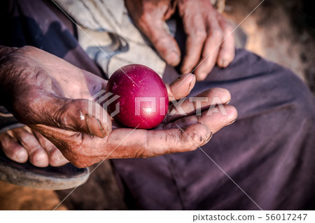 red eggs in the old man's hand 56017247
