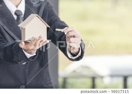Real estate agent showing new house and bank note 56017315