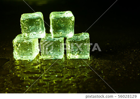 Green ice cubes on black table background. Green ice cubes on black table background. 56028129