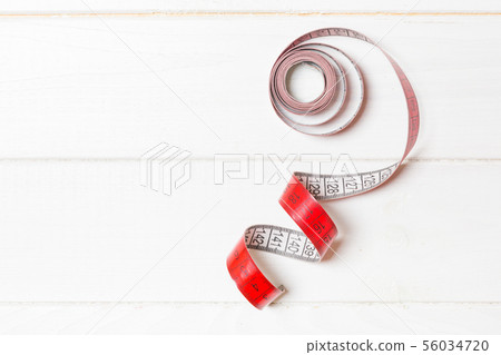 Top view of curled measure tape on wooden Top view of curled measure tape on wooden 56034720