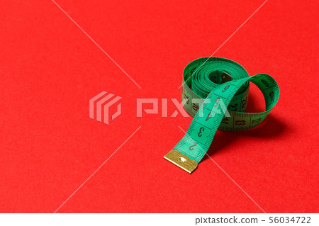 Perspective view of balled measuring tape on red Perspective view of balled measuring tape on red 56034722