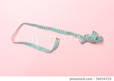 Top view of curled measure tape on pink Top view of curled measure tape on pink 56034729