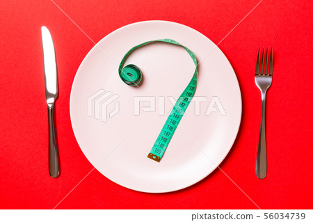 Fork and plate with measuring tape on color 56034739