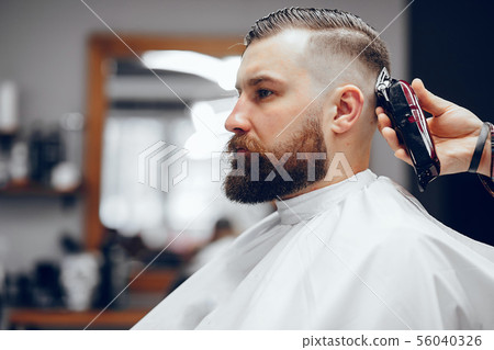 Stylish man sitting in a barbershop Stylish man sitting in a barbershop 56040326