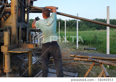 The workers drill wells on the water in the The workers drill wells on the water in the 56040953