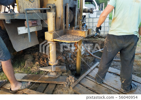 The workers drill wells on the water in the The workers drill wells on the water in the 56040954