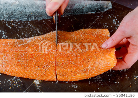 Healthy preparation chef is cuting salmon 56041186