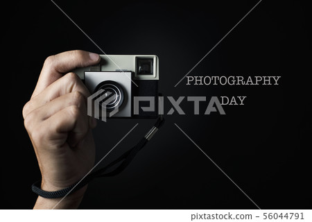man with a film camera and text photography day. 56044791