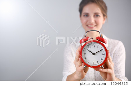Wonderful woman holding wake-up clock Wonderful woman holding wake-up clock 56044815
