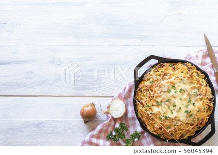 Melted cheese on pasta in an iron pan. German food Melted cheese on pasta in an iron pan. German food 56045394