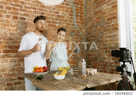 Young couple cooking and recording live video for vlog and social media Young couple cooking and recording live video for vlog and social media 56046602