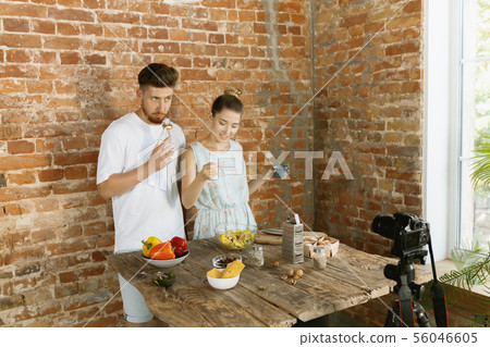 Young couple cooking and recording live video for vlog and social media Young couple cooking and recording live video for vlog and social media 56046605