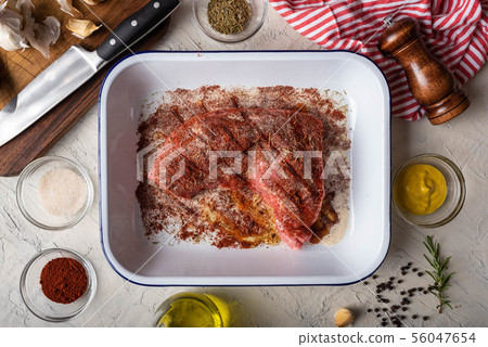 rubbing santa maria style sauce on tri-tip steak 56047654