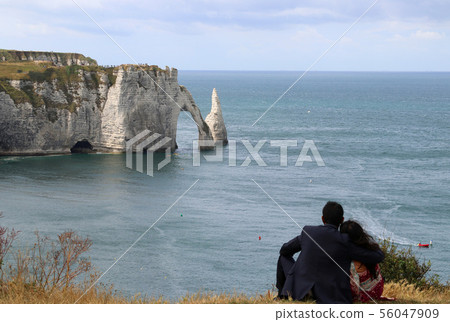 Couple looking at Etretat's White Cliff 56047909