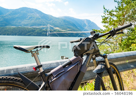 Theme of mountain biking in Scandinavia. human tourist in helmet and sportswear on bicycle in Norway Theme of mountain biking in Scandinavia. human tourist in helmet and sportswear on bicycle in Norway 56048196