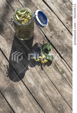 Jar with Linden blossom on wooden table. 56049415