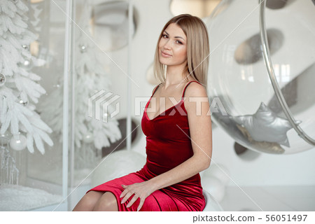 Happy young lady with straight blond hair near a white Christmas tree. New Year concept 56051497