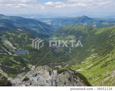 Beautiful vivid blue mountain lake Rohacske pleso with green mountain peaks and hiking path. view 56052116