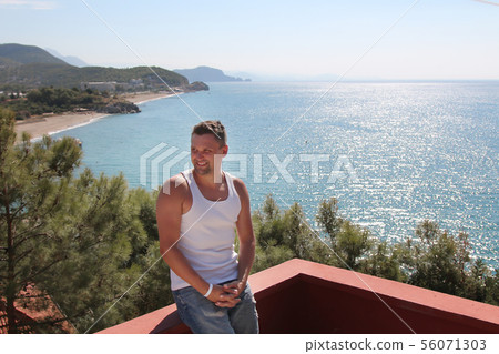 the concept of tourism, leisure is a beautiful man, basking in the white dress on the balcony of the 56071303