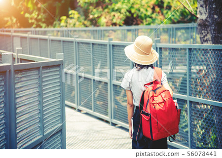 traveling backpacker walking on Canopy walkway at 56078441