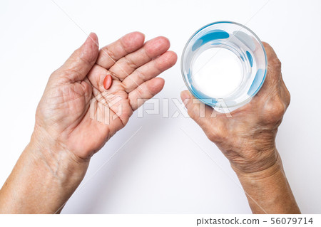 Senior woman's hands hold pills in bottle, glass Senior woman's hands hold pills in bottle, glass 56079714