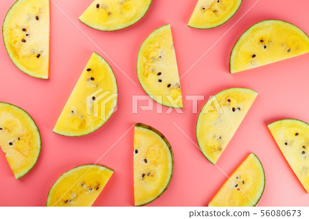 Slice of Yellow watermelon on a pink background. 56080673
