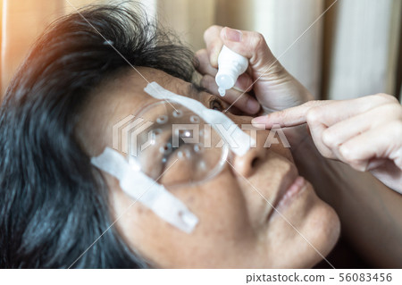Elderly patient woman having eye drop care Elderly patient woman having eye drop care 56083456