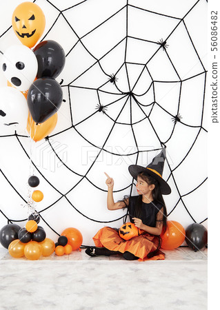 Happy Halloween little witch with a pumpkin 56086482