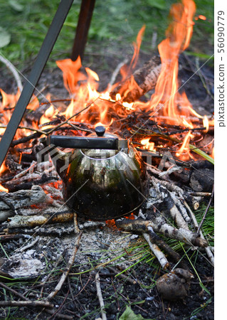 old shiny metal kettle basks on a fire, travel old shiny metal kettle basks on a fire, travel 56090779