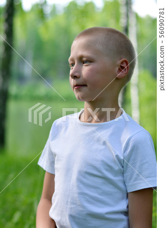 teenager boy in a white T-shirt walks in the woods 56090781