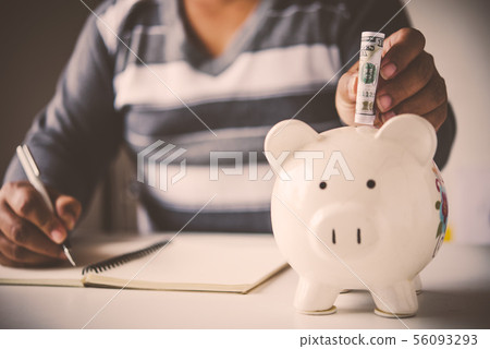Hands are money into a piggy bank - concept of Hands are money into a piggy bank - concept of 56093293