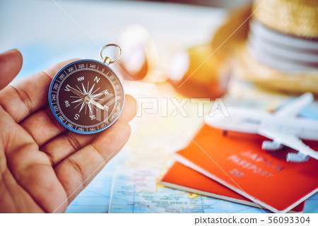 Tourists hold a compass and locate a place on a Tourists hold a compass and locate a place on a 56093304