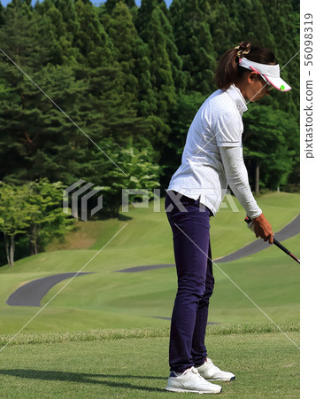 Woman hitting the tee shot Woman hitting the tee shot 56098319